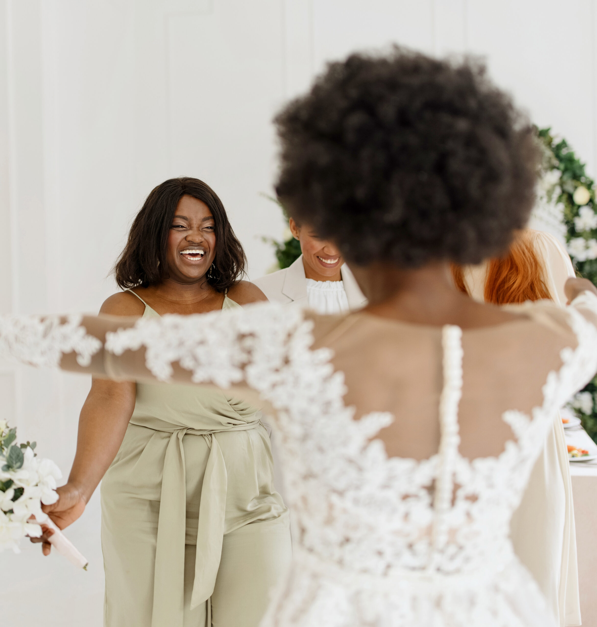 Young African bride throwing flower bouquet to her girl friends